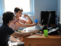 Two boys sitting looking at a computer screen