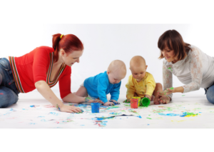 Two women playing two two babies and paint