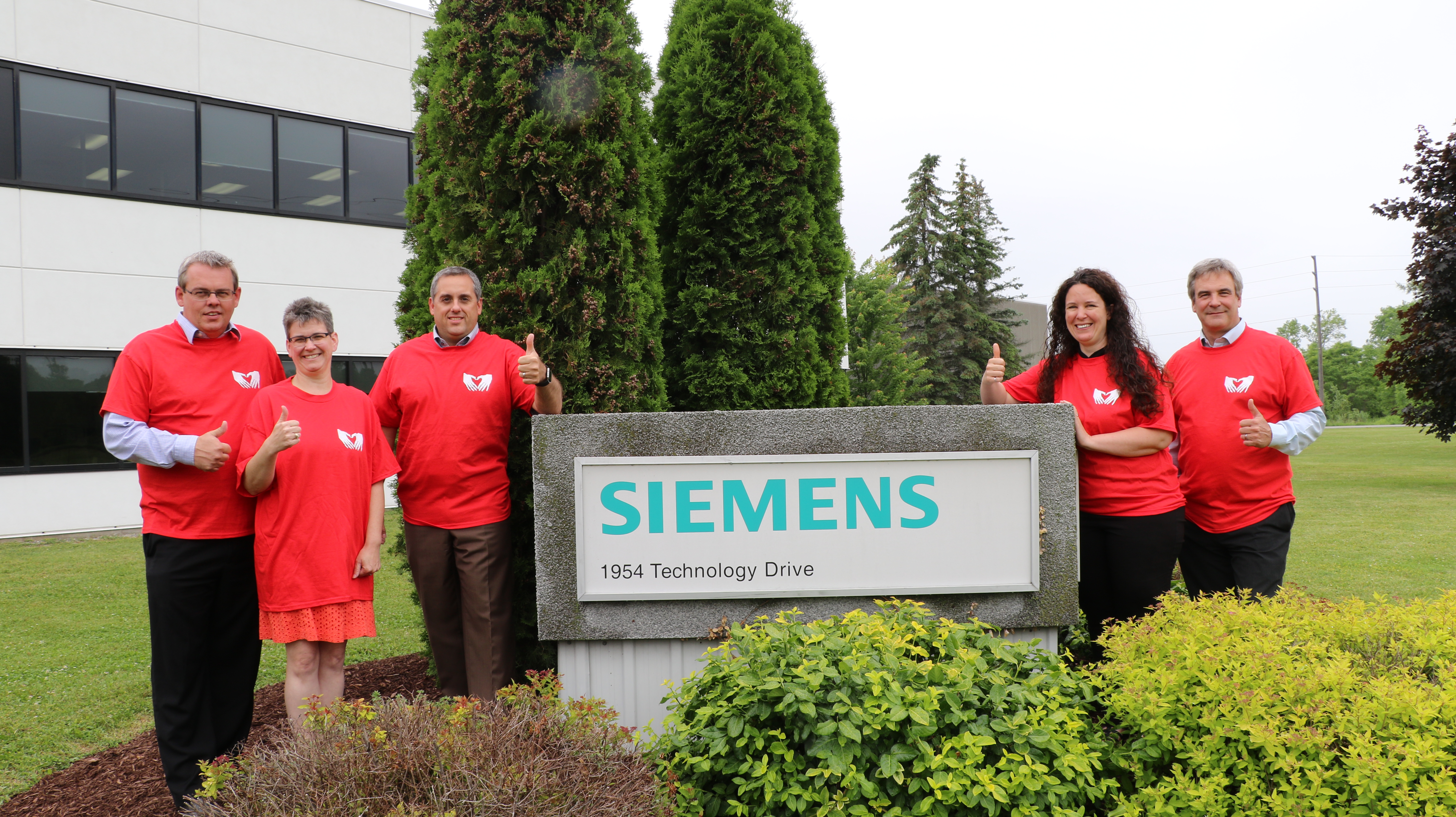 Siemens Peterborough staff pose in front of their company sign