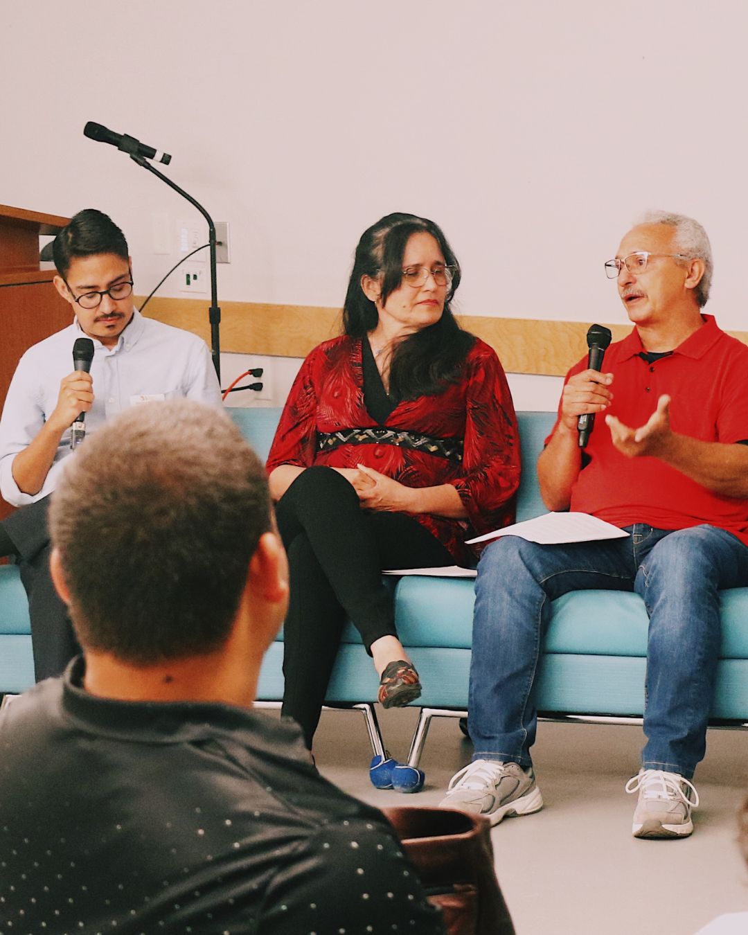 2 men and 1 woman speaking at a panel discussion